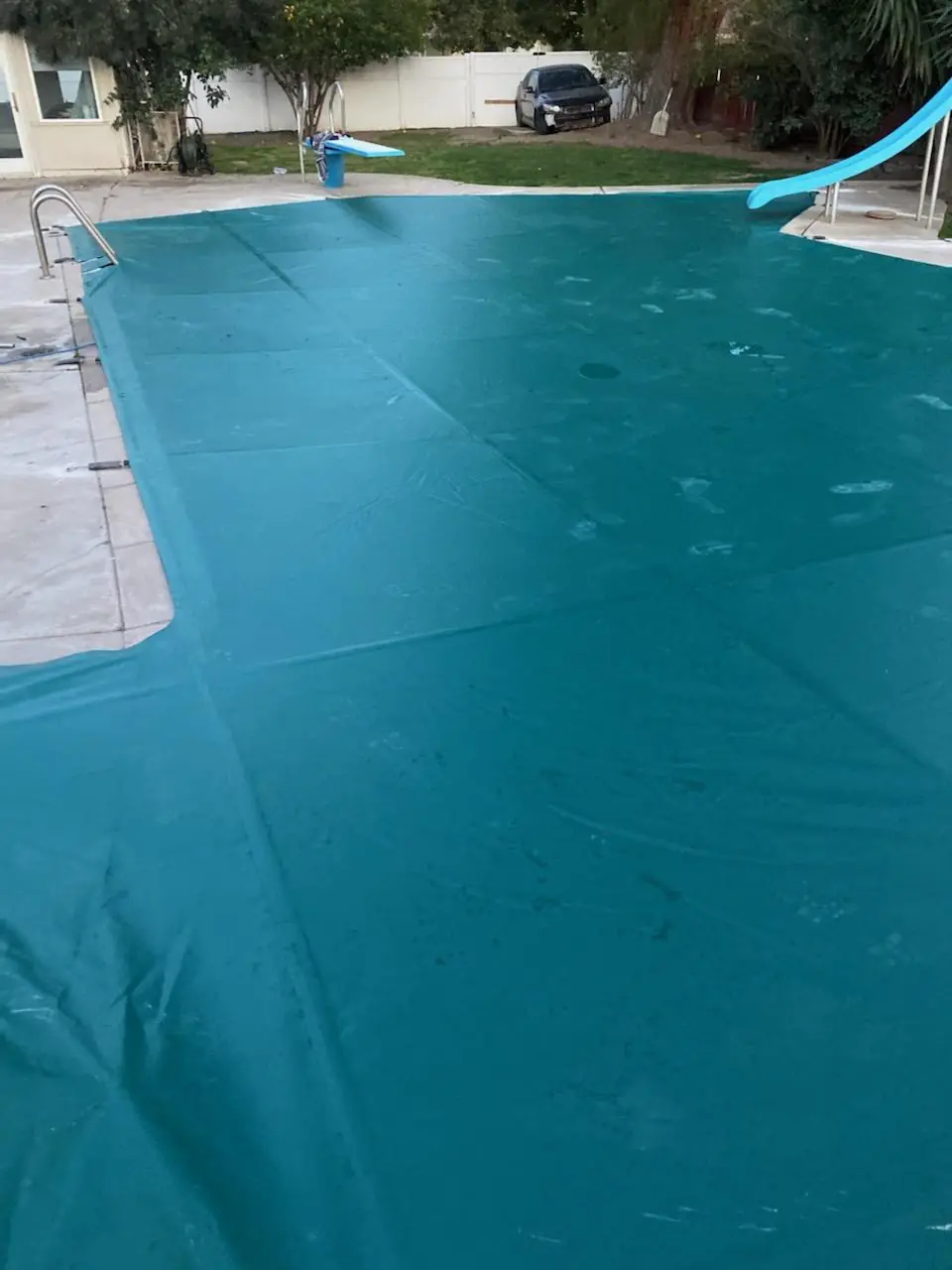 Custom waterproof 18 oz vinyl pool cover fabricated to fit around a slide